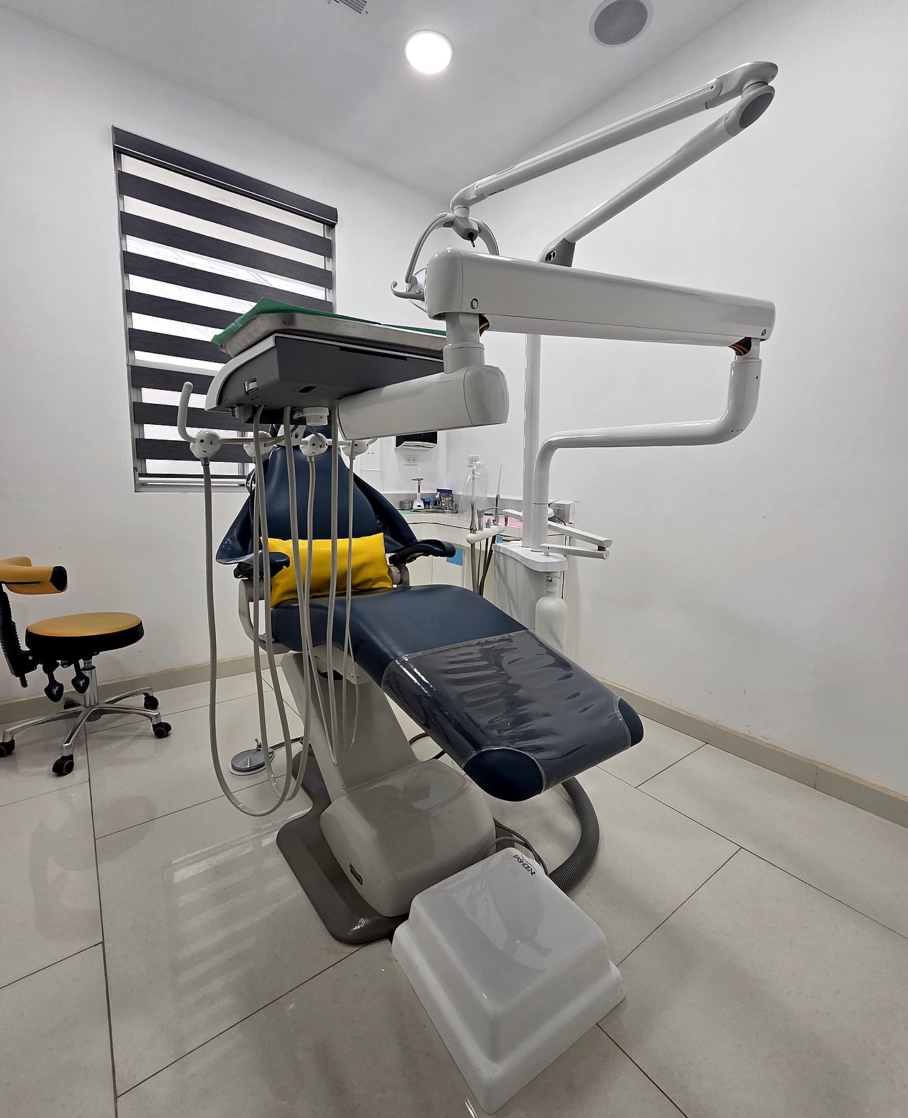 Full operatory suite with dental chair, surgical light, and clinical equipment.