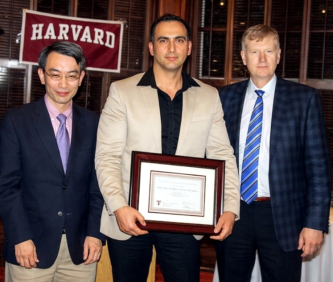Dr. Jose Jimenez holding his Harvard implant dentistry credential with faculty.